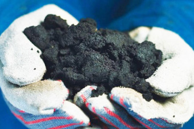 Worker holding Oil Sands tar in Alberta Canada Babcock Wilcox