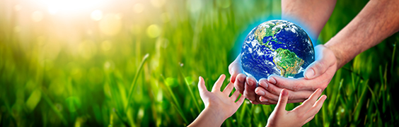 adult handing globe to child with green grass in background