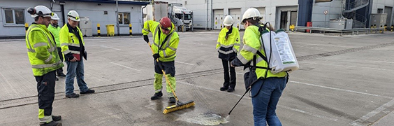 five engineers in safety vests cleaning ground
