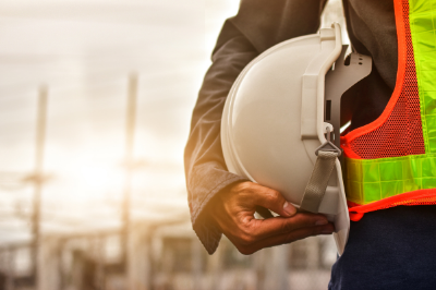 A person's arm wrapped around a hardhat