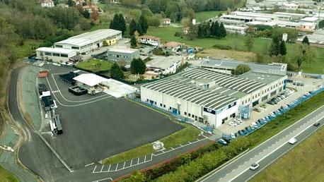 Aerial view of a large commercial warehouse, office building and parking lot