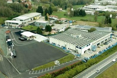 Aerial view of a large commercial warehouse, office building and parking lot