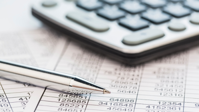 Calculator and ballpoint pen on financial documents