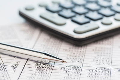 Calculator and ballpoint pen on financial documents