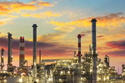 Exterior photograph of an oil refinery at dusk