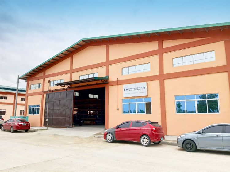 Industrial office and warehouse building with three cards parked in front of an open bay door