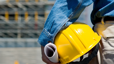 Person holding a hard hat under their arm