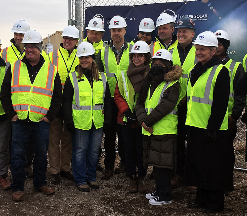 a group of people in hard hats and safety vests pose for a photograph