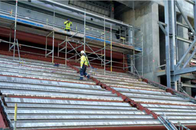 a man walking on an open combustion grate at a power plant under construction