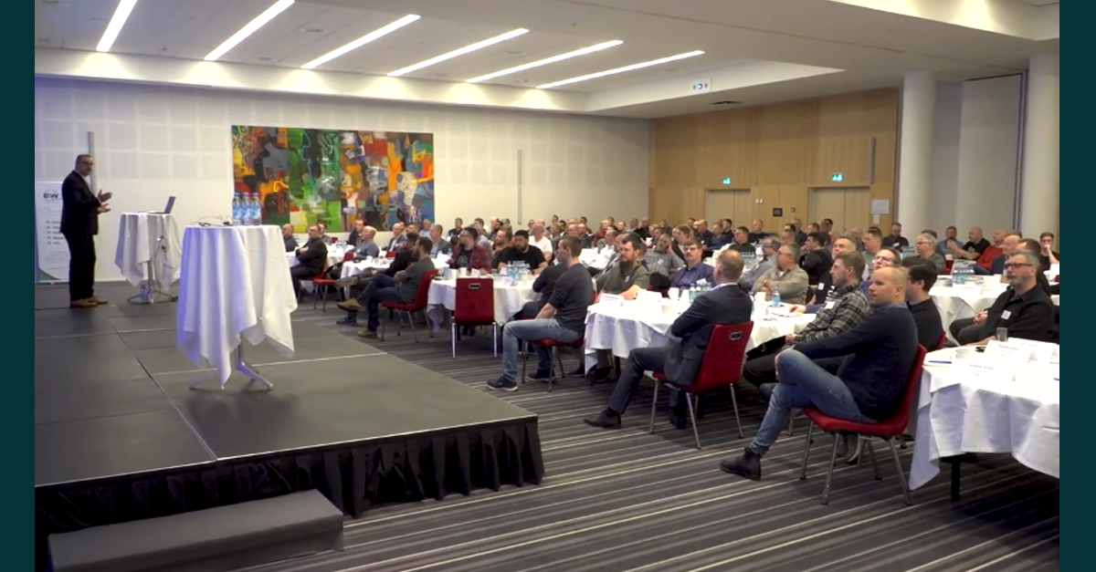 crowd of people seated at tables in a conference room
