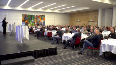 crowd of people seated at tables in a conference room