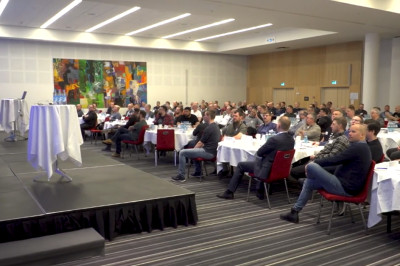 crowd of people seated at tables in a conference room